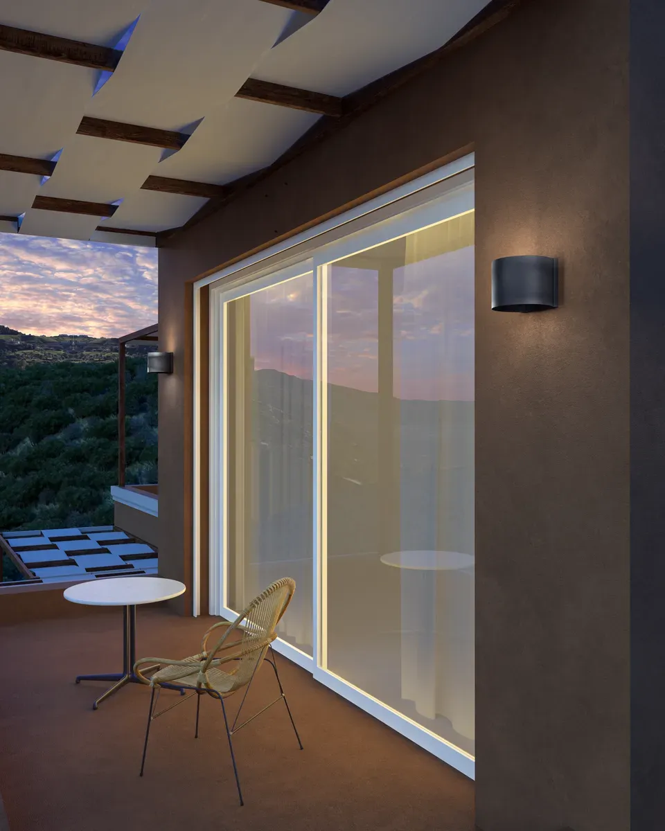 Aplique de pared exterior de líneas modernas iluminando una fachada al anochecer